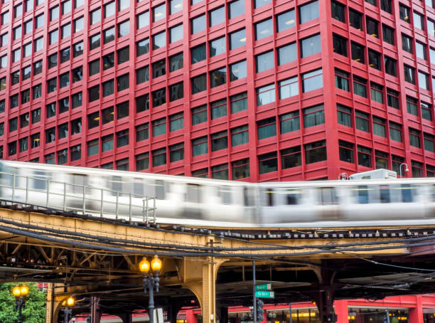 istock Train on elevated tracks within buildings at the Loop, Glass and Steel bridge between buildings - Long Exposure,  Chicago City Center - Chicago, Illinois, USA 868277970