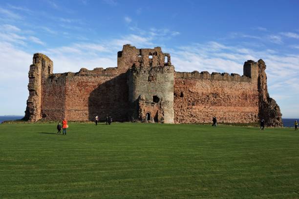 Tantallon Castle North Berwick, East Lothian, Scotland - October 27, 2017: View of the front of Tantallon Castle near North Berwick, Scotland, with visitors in the late October sunshine. The curtain wall forming the castle front is made of red sandstone The grass area is the old Outer Court. north berwick scotland east lothian castle scotland stock pictures, royalty-free photos & images