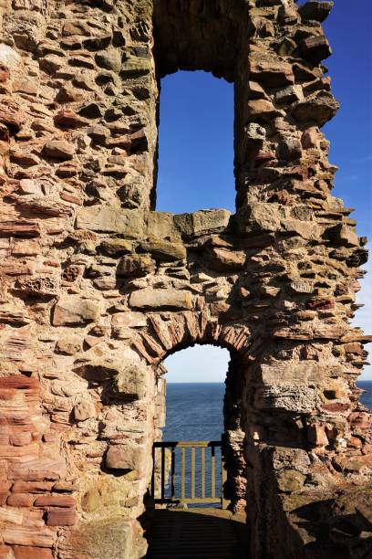 Tantallon Castle North Berwick, East Lothian, Scotland - October 27, 2017: View of the sky and the sea through a couple of window spaces in the sandstone curtain wall of Tantallon Castle in the late October sunshine. The water visible through the lower gap is the outer reaches of the Firth of Forth where it merges into the North Sea. north berwick scotland east lothian castle scotland stock pictures, royalty-free photos & images