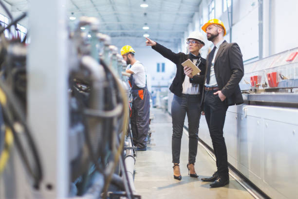 Quality inspectors team at factory Portraits of workers in factory. Shallow DOF. Developed from RAW; retouched with special care and attention; Small amount of grain added for best final impression. 16 bit Adobe RGB color profile. inspector stock pictures, royalty-free photos & images