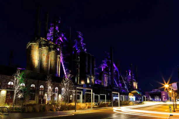 Bethlehem steel stacks turned into public entertainment area in downtown with concert center. Lit at nighttime with multi colored lights.