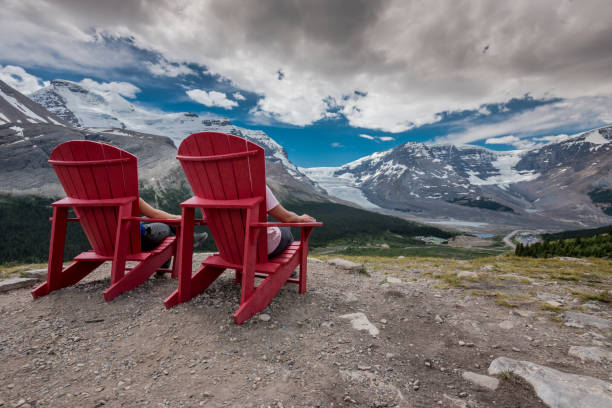 istock Behind View of Two People Sitting in Red Chairs 868296588