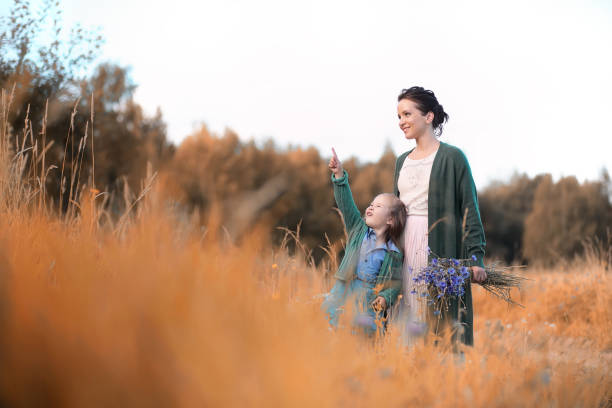 Beautiful young mother with daughter walking on a road
