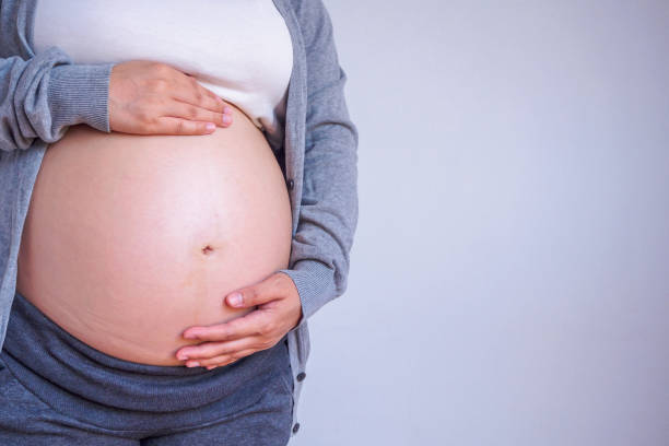 istock pregnant woman touching her belly close up 868324184