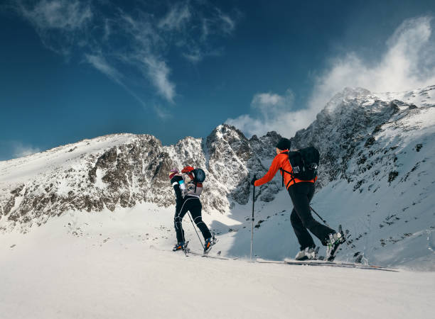 istock Two women ski walkers go up on the mountain top 868324400