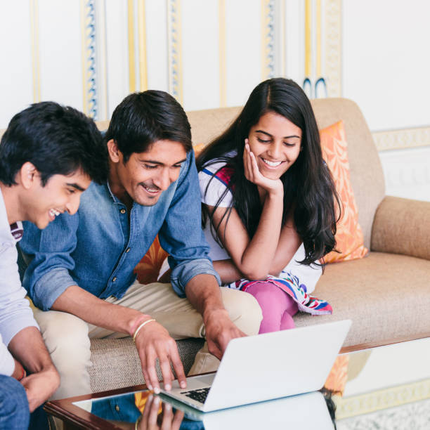 istock Group of indian millennials looking at a laptop and talking about business, homework or project together. 868324808
