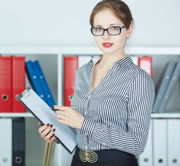 istock Smiling business woman holding document on clipboard. 868325396