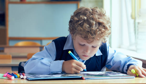 愛らしい小さな小学生マーカーを押しながら宿題の肖像画。 - elementary student little boys classroom child ストックフォトと画像