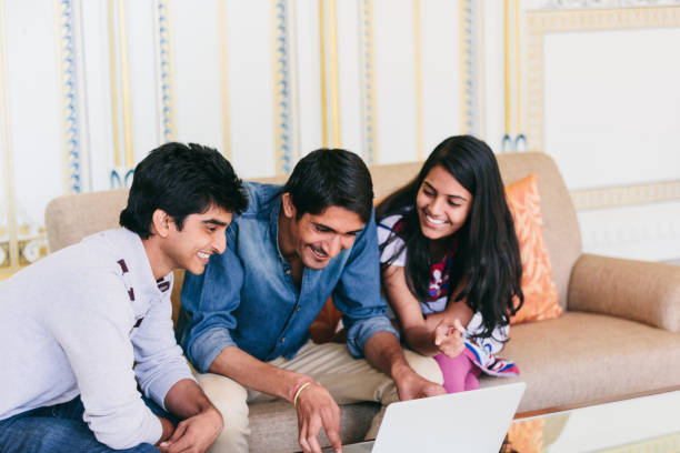 istock Group of indian millennials looking at a laptop and talking about business, homework or project together. 868325734