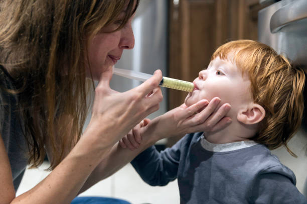 madre dando penicilina medicina enferma su bebé niño - penicillin fotografías e imágenes de stock