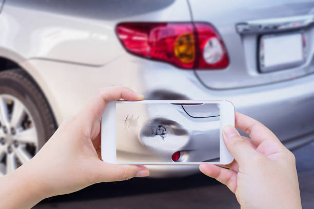 mujer con móvil smartphone tomar foto de daños para el seguro de accidente de coche - accidente de automóvil fotos fotografías e imágenes de stock