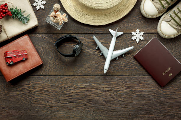 Above view shot of accessories fashion lifestyle to travel and Merry Christmas & Happy new year concept.Passport & clothes with many essential winter season background.Several objects on brown plank. stock photo