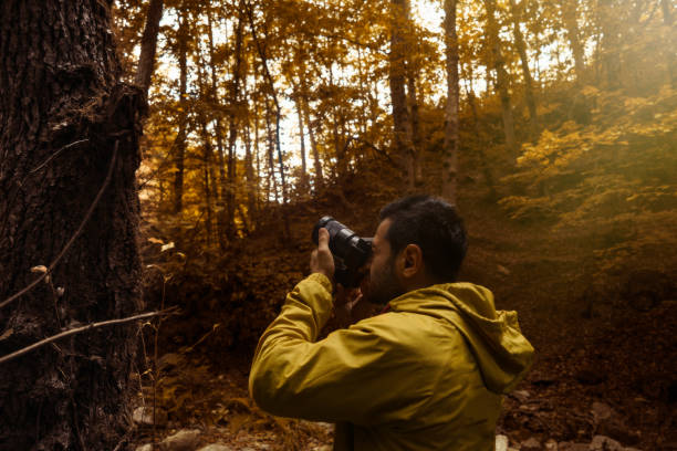 istock photographer man in autumn - forest 868334132