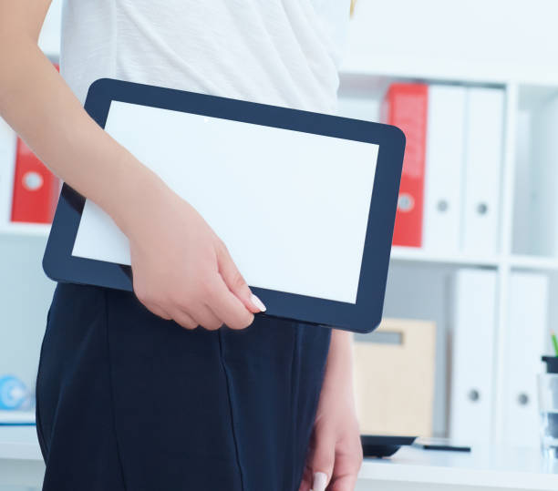 istock Young famale secretary holding tablet in hands. Tablet with empty space for advertising. 868335698
