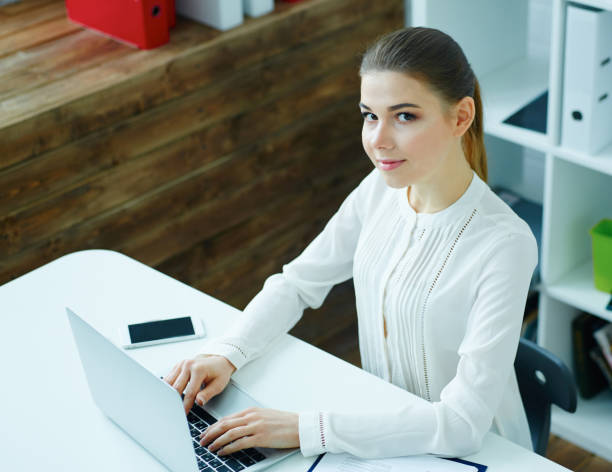 istock View from above. Young male businessman taking notes on laptop, working with data graph, sitting in office. Business, exchange market, job offer, analytics research, excellent education, certified public accountant concept. 868335714