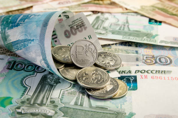 istock Russian roubles coins and Euro coins on banknotes. 868346062