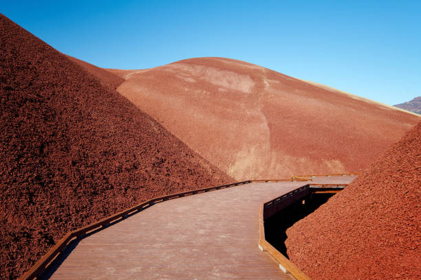 istock Red Clay Hills with Blue Sky and Wooden Foot Path 868359394