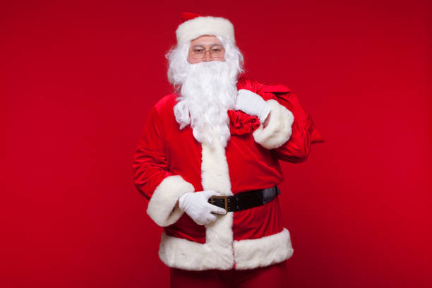 istock Christmas. santa claus with big bag on shoulder is on red background 868362854