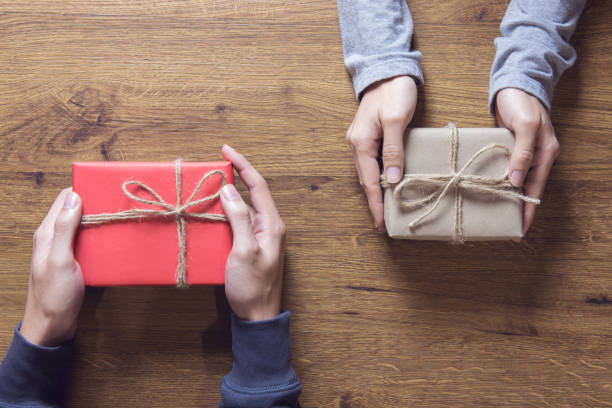 istock Man Hands holding craft paper gift box on table wood background and copy space. 868365764