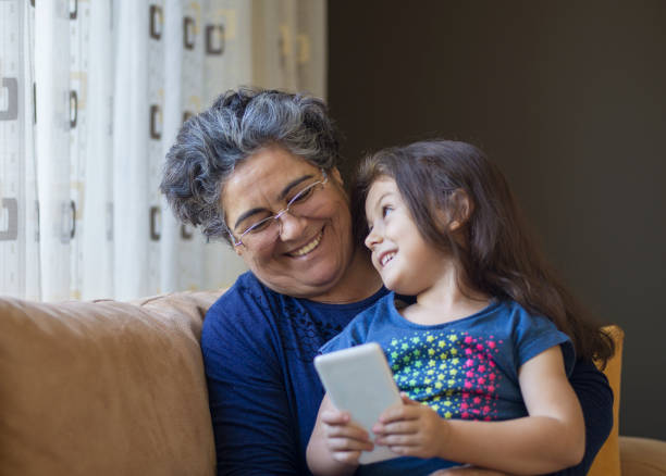 istock Little girl with grandmother using mobile phone 868376946