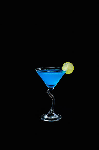 istock Blue alcohol cocktail with lemon slice isolated on black background 868381372