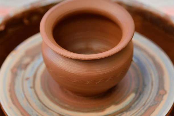 istock Potter making ceramic pot on the pottery wheel 868389240