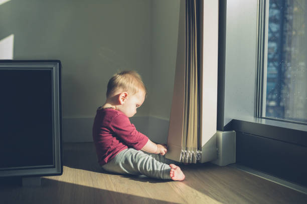 istock LIttle baby sitting by the window 868389968