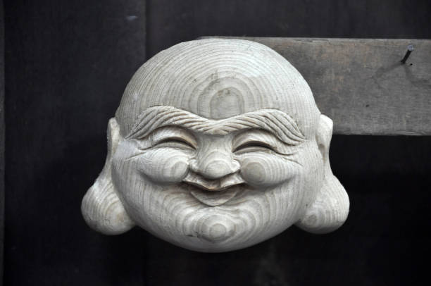 Handmade smiling Buddha wooden statue in Vietnam