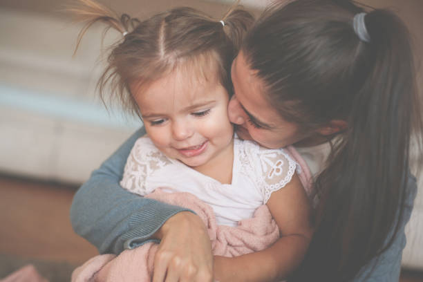 istock Mother enjoying with her daughter at home and hugging her. 868392390