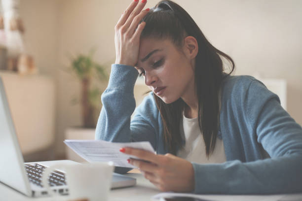 istock Worried woman at home using laptop and having problem. 868392574