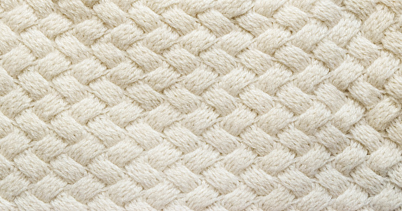 Detalle de alfombra de punto blanco. Textura de textil de fondo blanco. Antecedentes detallados de hilo caliente. De punto de lana beige Cachemira. Tela de lana natural, fragmento de suéter. photo