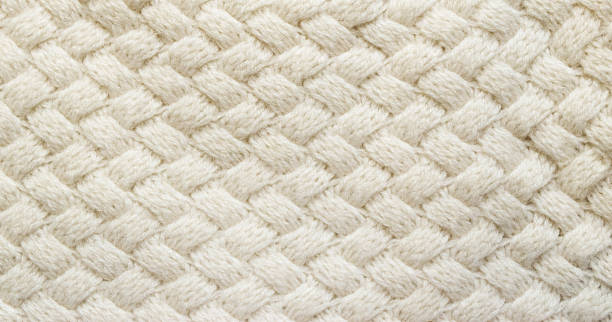 White knitted carpet closeup. Textile texture off white background. Detailed warm yarn background. Knit cashmere beige wool. Natural woolen fabric, sweater fragment. Wool close up background, beige color. Wide woolen textured fabric. crochet photos stock pictures, royalty-free photos & images