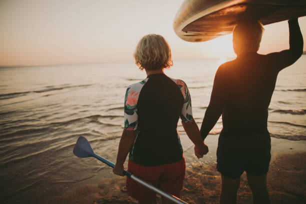 senior surfers - women sea cheerful surfing fotografías e imágenes de stock