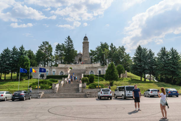 arges, roménia - 15 de agosto de 2017: turista visitar o mausoléu de heróis situado na colina de mateias. o monumento é dedicado aos heróis 1ª guerra mundial. - tirgoviste - fotografias e filmes do acervo