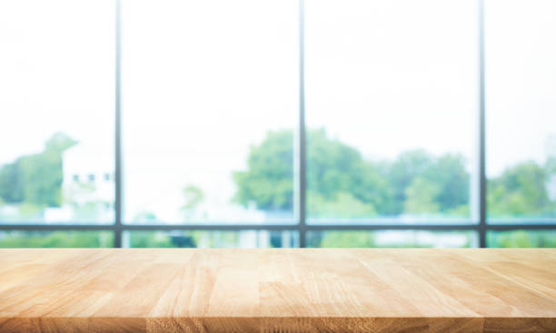istock Wood table top on blur green garden from window view. 868405762