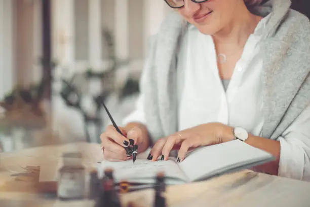 Photo of Young businesswoman is writing in a personal organizer