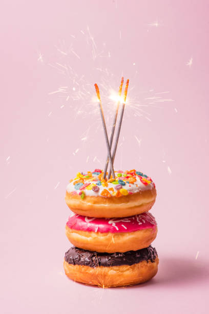 istock Delicious donuts for birthday on pastel pink background. 868422252