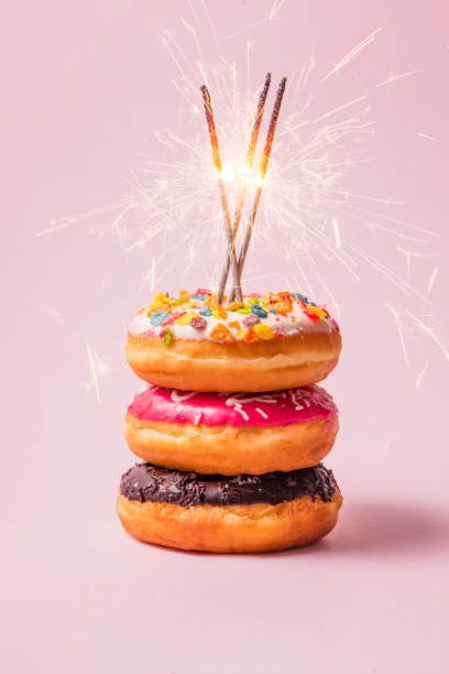 istock Delicious donuts for birthday on pastel pink background. 868422312