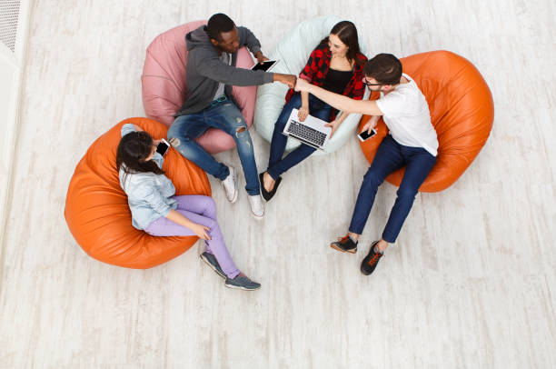 istock Friends using gadgets, sitting indoors in line 868422436