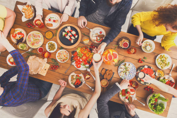 istock People eat and share healthy meals at served table dinner party 868424846