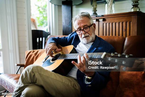 An Elderly Man Is Playing Guitar Stock Photo - Download Image Now - Senior Adult, Hobbies, Playing