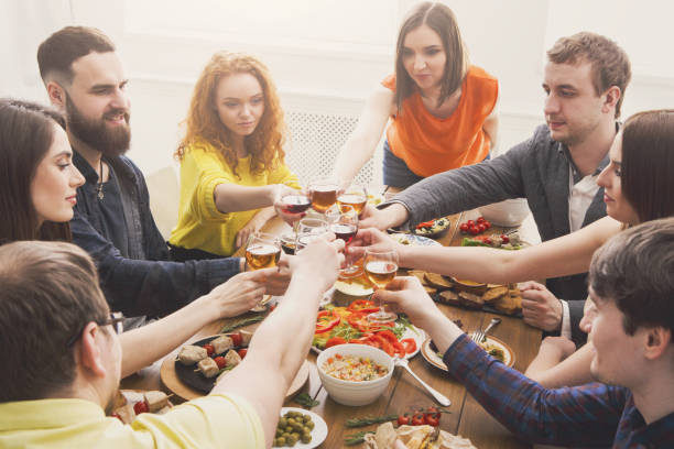 istock People say cheers clink glasses at festive table dinner party 868424920