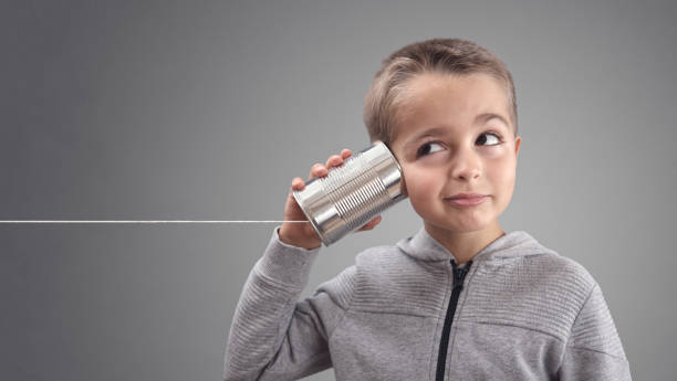 Tin can phone listening to curious good news Boy on tin can phone listening to curious good news string telephone stock pictures, royalty-free photos & images