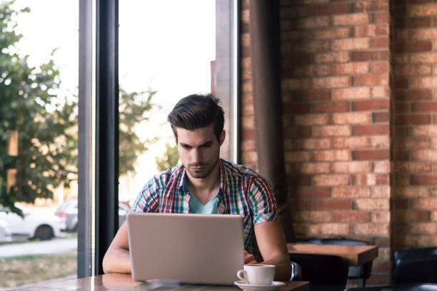 istock man surfing the web in Internet cafe 868429810