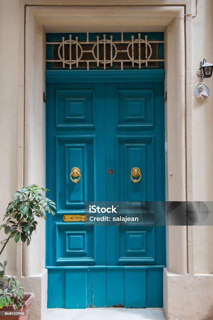 Traditional wooden painted turquoise door in Malta Traditional wooden, vintage painted turquoise door in Malta Ancient Stock Photo