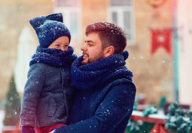 istock happy family under the snowfall during winter holidays 868436526