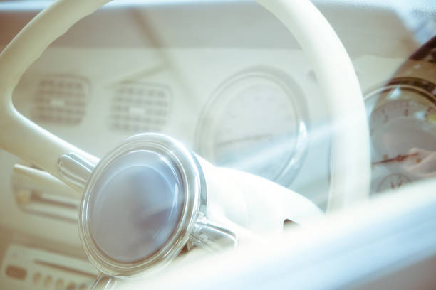 Vintage interior of an old car with a retro dashboard and steering wheel in a PVC cover.