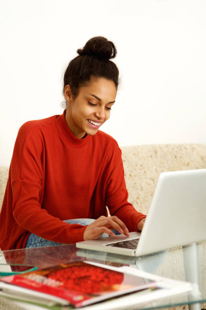 istock Cool young woman working on laptop at home 868441690