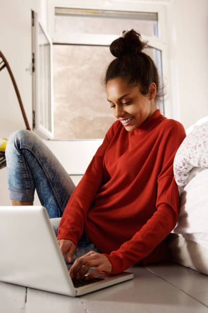 istock Female student sitting on floor at home with laptop 868441826