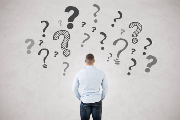 istock Backside of a young fit man with question marks around him, isolated in grey 868446960